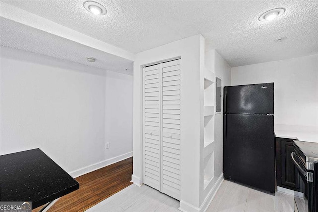 383 Ralph Mcgill Blvd NE Unit J, Atlanta, GA 30312 - kitchen with freestanding refrigerator, electric range, a textured ceiling, dark cabinets, and light countertops
