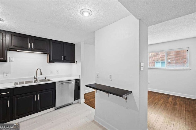 383 Ralph Mcgill Blvd NE Unit J, Atlanta, GA 30312 - kitchen featuring stainless steel dishwasher, a textured ceiling, dark cabinets, light countertops, and light wood-style flooring