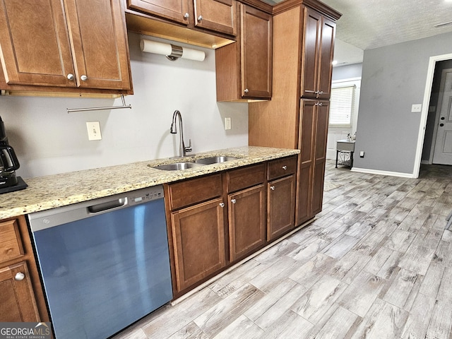100 Lexington Pl, Senoia, GA 30276 - kitchen featuring stainless steel dishwasher, light stone countertops, a textured ceiling, light wood-style flooring, and brown cabinets