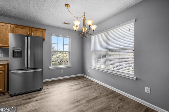 7 Springwater Dr, Port Wentworth, GA 31407 - kitchen with stainless steel refrigerator with ice dispenser, a chandelier, a textured ceiling, brown cabinets, and wood finished floors