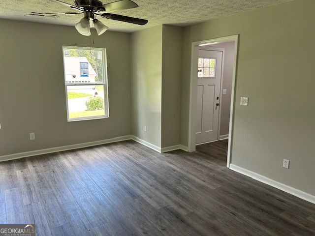433 Rhett Dr, Loganville, GA 30052 - unfurnished room with dark wood-style floors, a textured ceiling, and a ceiling fan