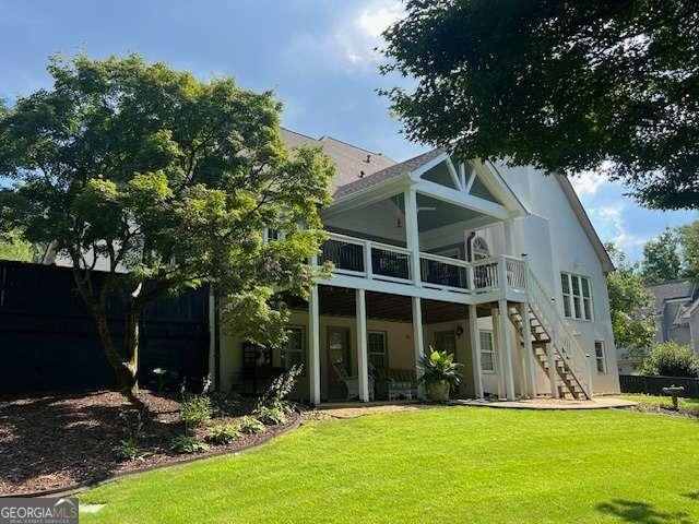 5085 Johns Creek Ct, Johns Creek, GA 30022 - rear view of property featuring stairway, a yard, a sunroom, and a deck