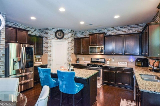 325 Paces Dr, Lithia Springs, GA 30122 - kitchen with appliances with stainless steel finishes, light stone countertops, dark brown cabinetry, dark wood-type flooring, and recessed lighting