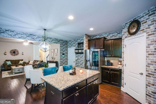 325 Paces Dr, Lithia Springs, GA 30122 - kitchen featuring dark wood finished floors, stainless steel fridge with ice dispenser, light stone countertops, dark brown cabinetry, and a center island