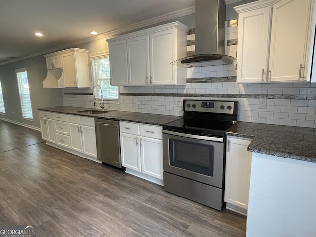 1833 Phillips Ave, East Point, GA 30344 - kitchen featuring appliances with stainless steel finishes, wall chimney exhaust hood, ornamental molding, dark wood-style floors, and white cabinets