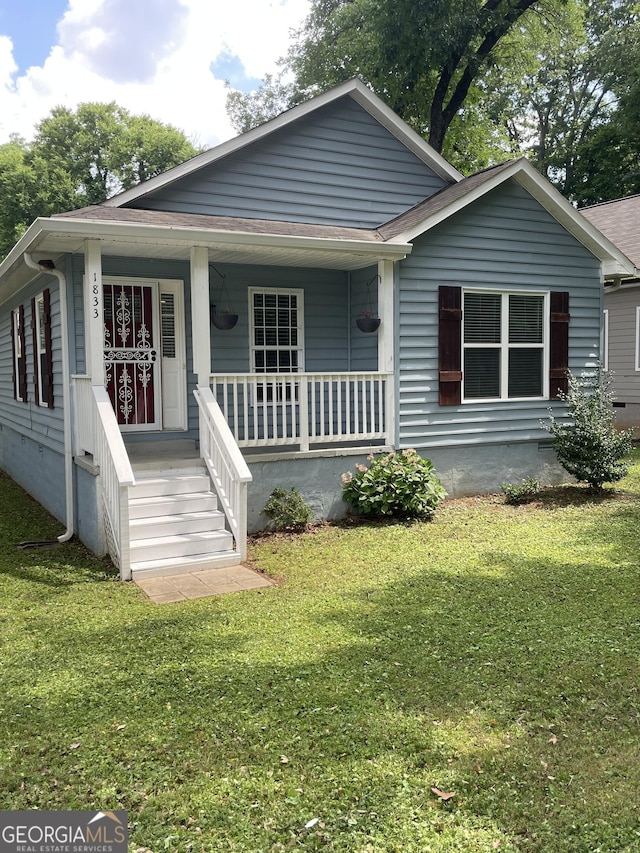1833 Phillips Ave, East Point, GA 30344 - bungalow-style home with covered porch, a front yard, and roof with shingles