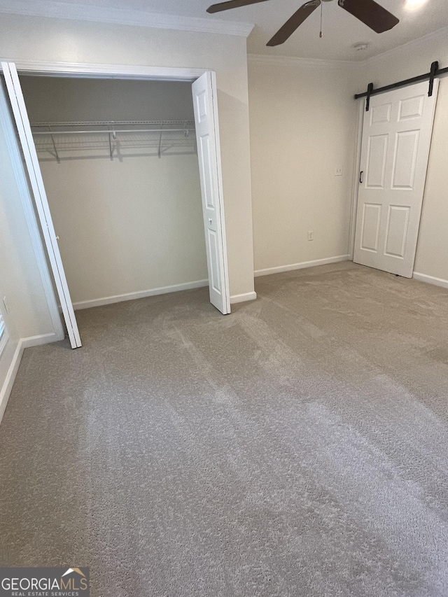 1833 Phillips Ave, East Point, GA 30344 - unfurnished bedroom featuring ornamental molding, a barn door, carpet flooring, a closet, and ceiling fan