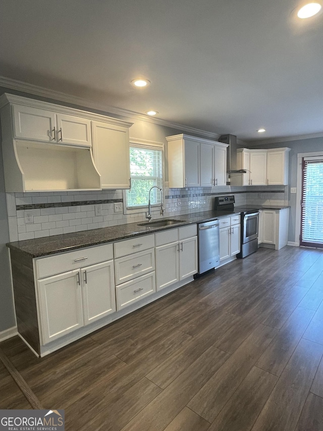 1833 Phillips Ave, East Point, GA 30344 - kitchen with stainless steel appliances, ornamental molding, wall chimney range hood, dark wood-style flooring, and plenty of natural light