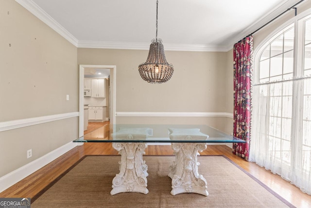 914 Champions Way, Mcdonough, GA 30252 - unfurnished dining area with wood finished floors, ornamental molding, and a chandelier