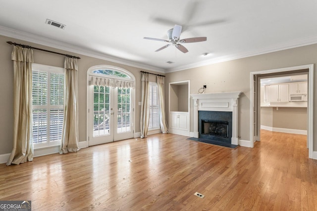 914 Champions Way, Mcdonough, GA 30252 - unfurnished living room featuring ceiling fan, a fireplace with flush hearth, crown molding, wood finished floors, and french doors