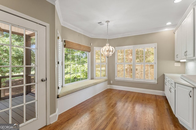 914 Champions Way, Mcdonough, GA 30252 - unfurnished dining area with a chandelier, ornamental molding, healthy amount of natural light, wood finished floors, and recessed lighting