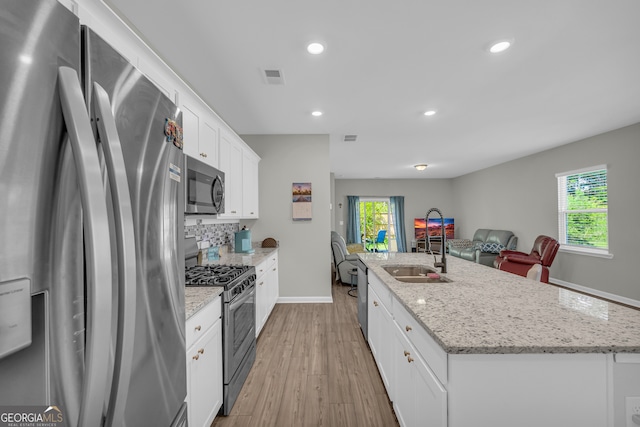 264 Golden Eagle Pkwy, Braselton, GA 30517 - kitchen featuring appliances with stainless steel finishes, a center island with sink, healthy amount of natural light, light wood-type flooring, and recessed lighting