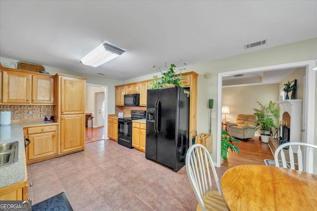 536 Sam Brown Blvd, Commerce, GA 30529 - kitchen with black appliances, tasteful backsplash, light countertops, and light brown cabinets
