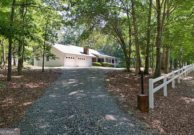 77 Chestatee Dr, Blairsville, GA 30512 - view of property exterior featuring an attached garage, gravel driveway, and a chimney