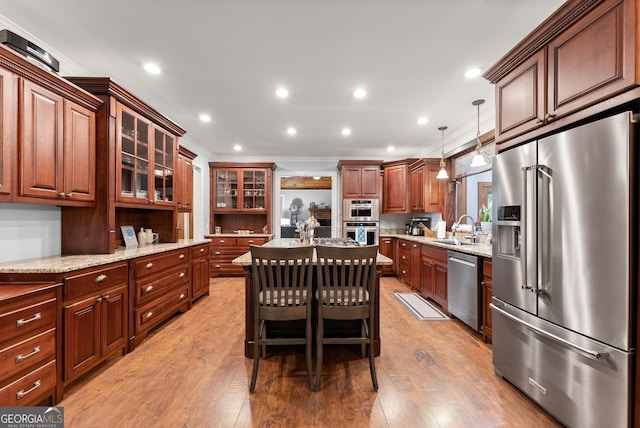 712 Meadow Run Ct, Clarkesville, GA 30523 - kitchen with stainless steel appliances, light stone countertops, glass insert cabinets, light wood-style flooring, and a center island