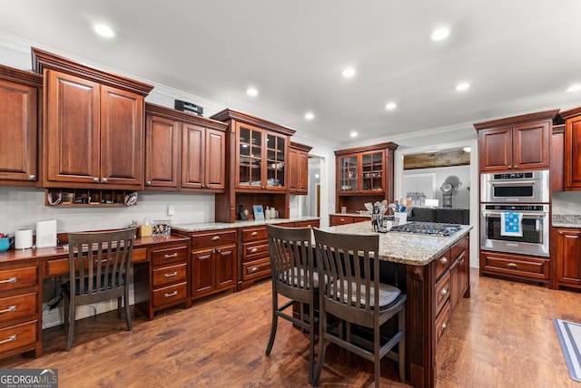 712 Meadow Run Ct, Clarkesville, GA 30523 - kitchen featuring crown molding, wood finished floors, built in desk, appliances with stainless steel finishes, and glass insert cabinets