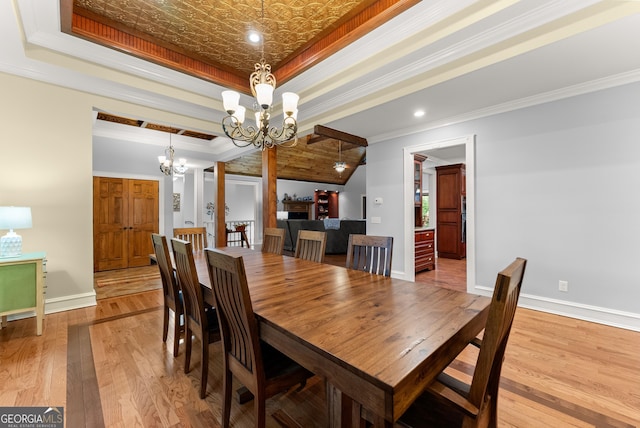 712 Meadow Run Ct, Clarkesville, GA 30523 - dining space featuring a raised ceiling, a chandelier, light wood-type flooring, and ornamental molding