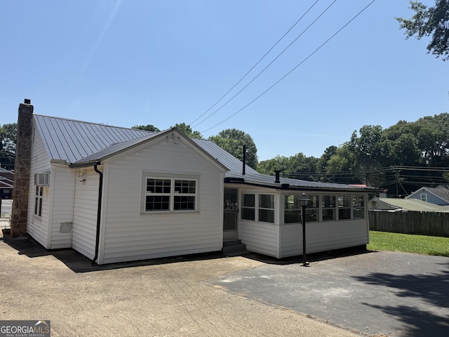 1220 Harmony St, Gainesville, GA 30501 - view of front of home with a metal roof, a chimney, a sunroom, entry steps, and a patio