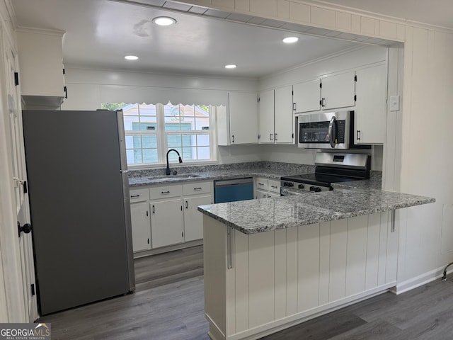 1220 Harmony St, Gainesville, GA 30501 - kitchen with stainless steel appliances, crown molding, a peninsula, dark wood-type flooring, and white cabinets