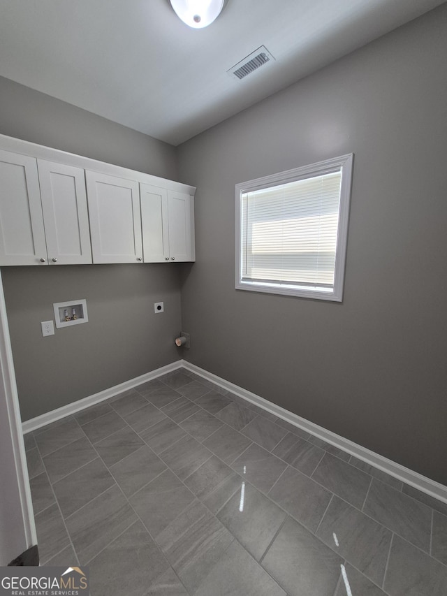1090 Fox Glen Dr, Watkinsville, GA 30677 - laundry room with hookup for a washing machine, electric dryer hookup, cabinet space, dark tile patterned floors, and gas dryer hookup