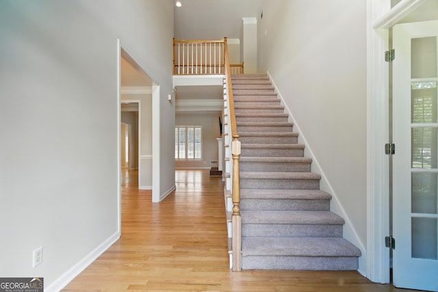 2832 Windrush Dr, Buford, GA 30518 - stairway featuring a towering ceiling, wood finished floors, and crown molding