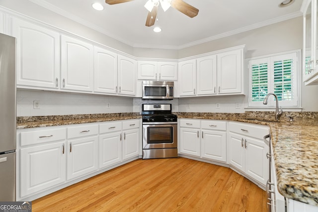 2832 Windrush Dr, Buford, GA 30518 - kitchen featuring stainless steel appliances, ceiling fan, white cabinets, light wood-style floors, and crown molding