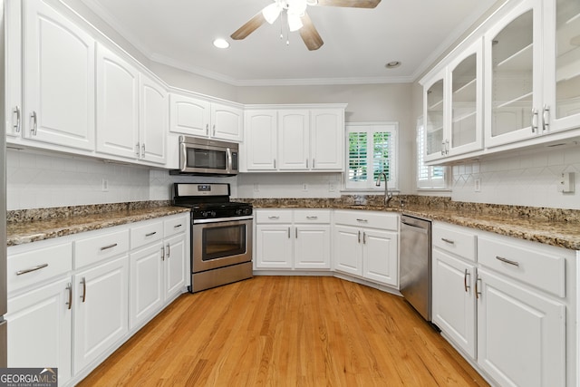 2832 Windrush Dr, Buford, GA 30518 - kitchen with stainless steel appliances, a ceiling fan, light wood-style floors, white cabinets, and backsplash
