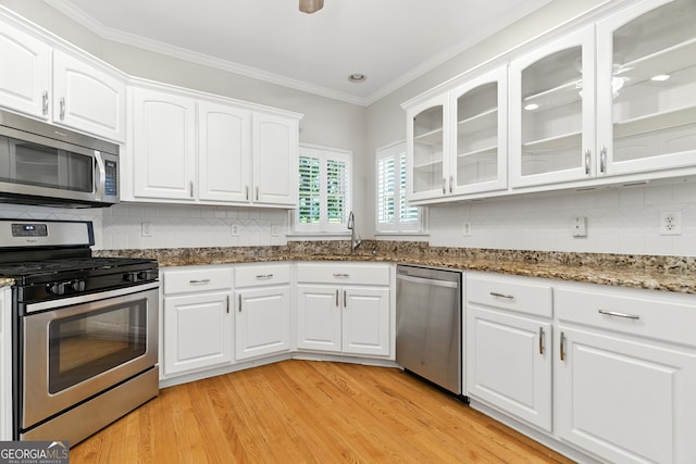 2832 Windrush Dr, Buford, GA 30518 - kitchen featuring appliances with stainless steel finishes, white cabinetry, light wood-style floors, decorative backsplash, and dark stone counters