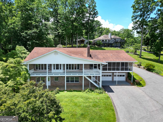 2722 Hidden Valley Rd, Hiawassee, GA 30546 - view of front of home featuring driveway, a garage, a chimney, brick siding, and a front yard