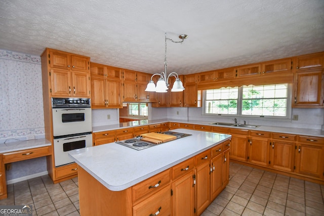 2722 Hidden Valley Rd, Hiawassee, GA 30546 - kitchen featuring double oven, stovetop with downdraft, light countertops, wallpapered walls, and a chandelier