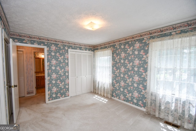 2722 Hidden Valley Rd, Hiawassee, GA 30546 - unfurnished bedroom featuring wallpapered walls, carpet flooring, a closet, and a textured ceiling
