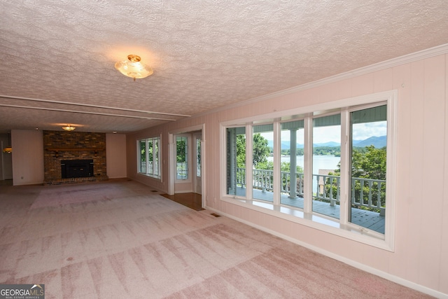 2722 Hidden Valley Rd, Hiawassee, GA 30546 - unfurnished living room with a brick fireplace, a textured ceiling, a water view, carpet, and ornamental molding