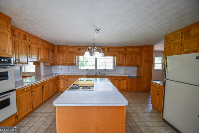 2722 Hidden Valley Rd, Hiawassee, GA 30546 - kitchen with white appliances, plenty of natural light, light countertops, a textured ceiling, and a kitchen island