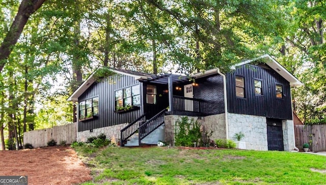 706 Powder Springs St SE, Smyrna, GA 30080 - view of front facade featuring board and batten siding, stone siding, an attached garage, and stairway