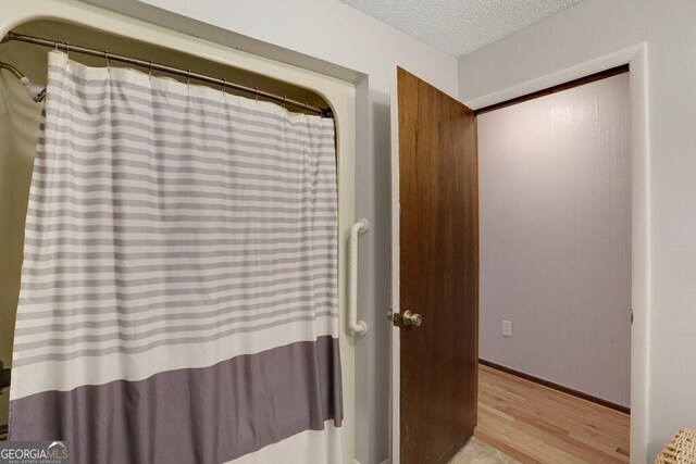 16 Lois Ln, Hayesville, NC 28904 - bathroom with wood finished floors, a textured ceiling, and a shower with shower curtain