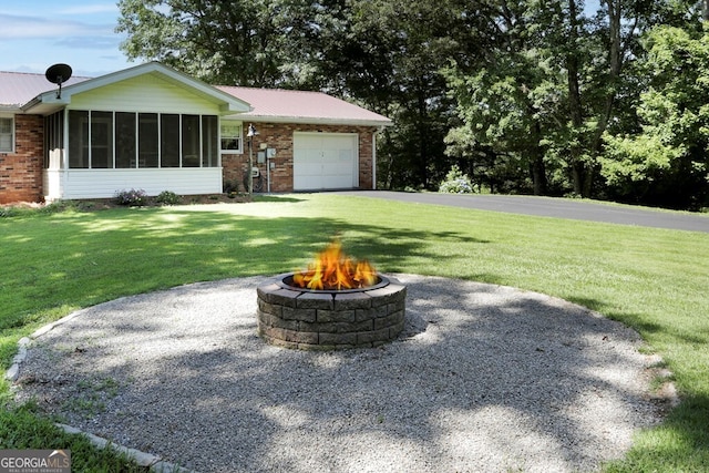 16 Lois Ln, Hayesville, NC 28904 - view of front of house with an outdoor fire pit, an attached garage, brick siding, a sunroom, and a front yard