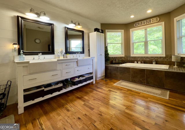 1780 Double Bridge Rd, Demorest, GA 30535 - full bathroom featuring a textured ceiling, wood finished floors, double vanity, and a bath