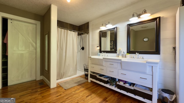 1780 Double Bridge Rd, Demorest, GA 30535 - bathroom featuring a shower stall, double vanity, wood finished floors, and a textured ceiling