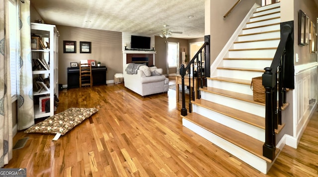 1780 Double Bridge Rd, Demorest, GA 30535 - living room featuring stairway, a ceiling fan, a fireplace, and wood finished floors