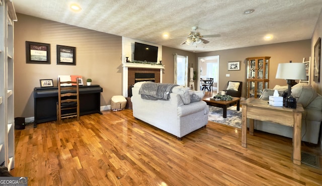 1780 Double Bridge Rd, Demorest, GA 30535 - living room with light wood-style flooring, a brick fireplace, ceiling fan, recessed lighting, and a textured ceiling