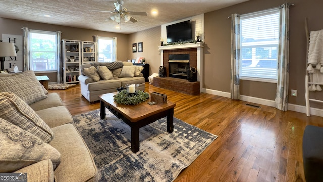 1780 Double Bridge Rd, Demorest, GA 30535 - living room featuring ceiling fan, a brick fireplace, wood finished floors, a textured ceiling, and recessed lighting
