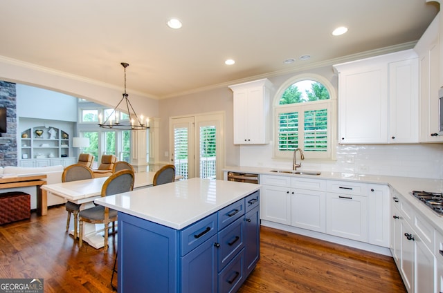4645 Wykeshire Ct, Cumming, GA 30041 - kitchen featuring blue cabinets, a chandelier, white cabinets, open floor plan, and light countertops