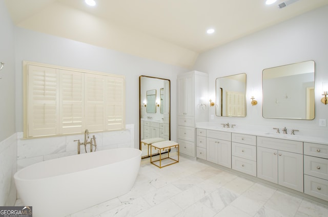 4645 Wykeshire Ct, Cumming, GA 30041 - full bathroom featuring double vanity, a freestanding bath, lofted ceiling, recessed lighting, and marble look tile flooring