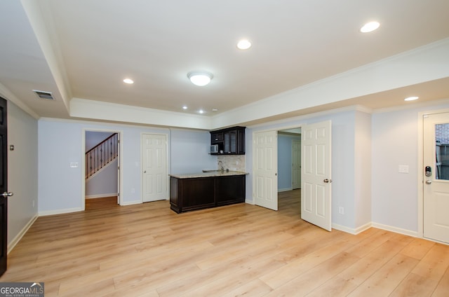 4645 Wykeshire Ct, Cumming, GA 30041 - kitchen with light countertops, crown molding, light wood-style floors, stainless steel microwave, and a peninsula