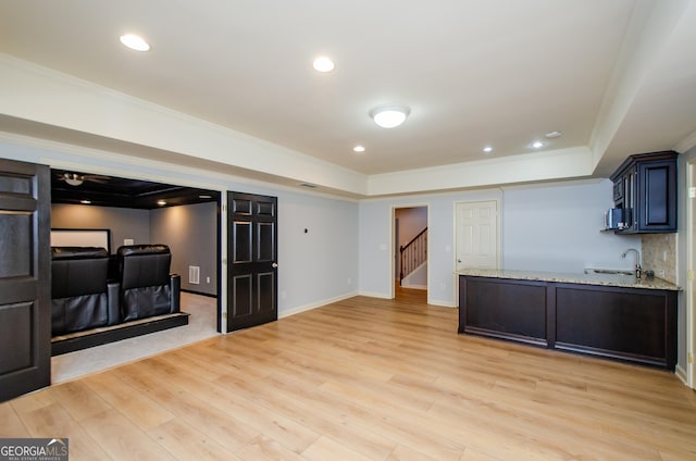 4645 Wykeshire Ct, Cumming, GA 30041 - kitchen with a raised ceiling, crown molding, light stone counters, light wood-type flooring, and a peninsula