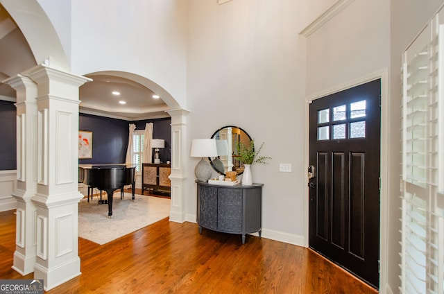 4645 Wykeshire Ct, Cumming, GA 30041 - foyer with decorative columns, wood finished floors, arched walkways, plenty of natural light, and a high ceiling