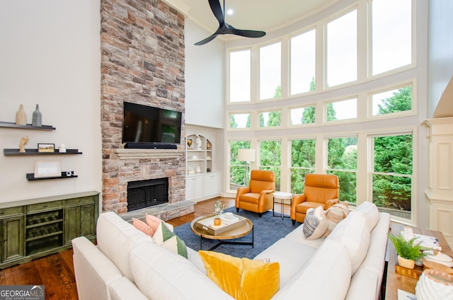 4645 Wykeshire Ct, Cumming, GA 30041 - living room with a high ceiling, dark wood finished floors, a ceiling fan, and a fireplace