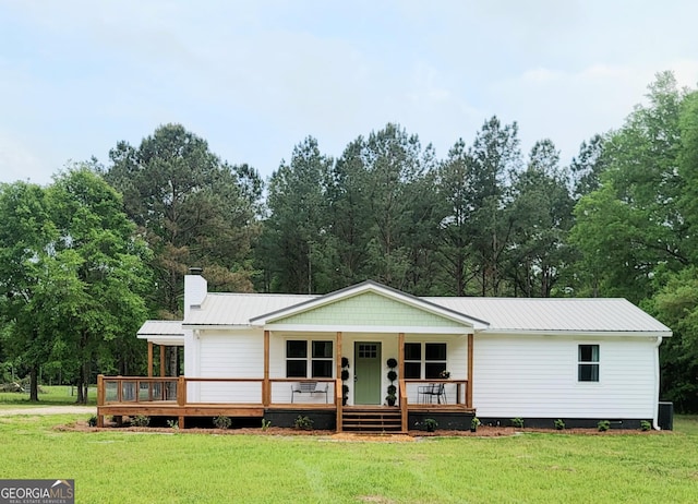 4749 Ga Highway 65, Pelham, GA 31779 - view of front of home featuring a front yard, a metal roof, covered porch, and a chimney