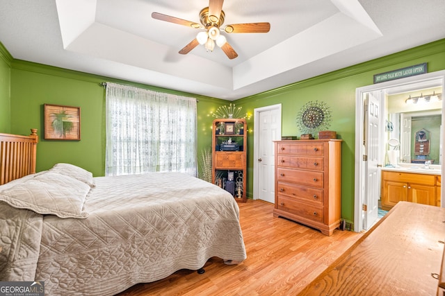 127 Poplar Mill Rd, Demorest, GA 30535 - bedroom featuring a raised ceiling, light wood-style floors, ensuite bathroom, and a ceiling fan