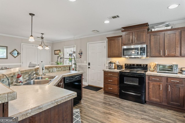 41 Bob White Ln, Newnan, GA 30263 - kitchen with black appliances, light countertops, crown molding, wood finished floors, and recessed lighting